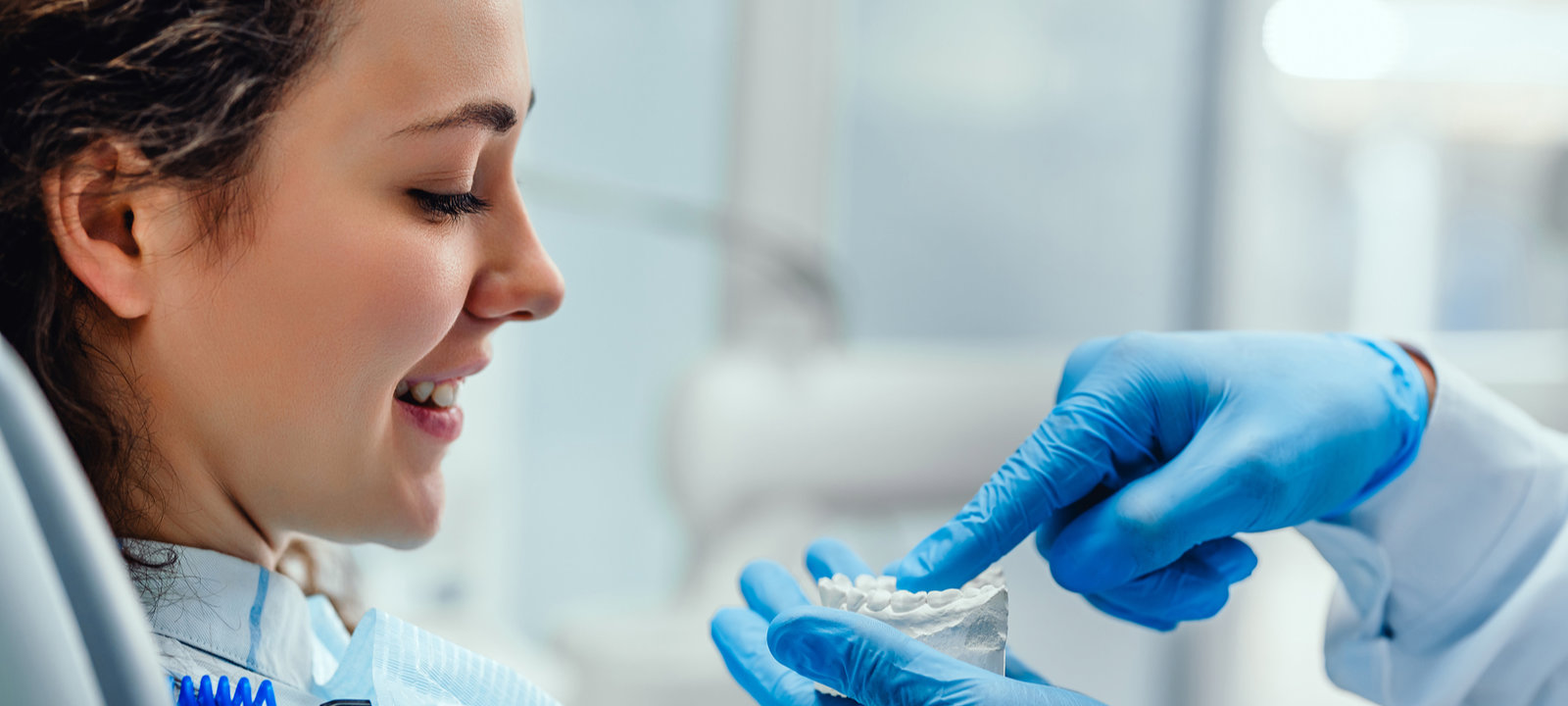 Male-Dentist-Explaining-His-Female-Patient-About-Teeth-Care